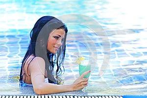 Woman in swimming pool with cocktail