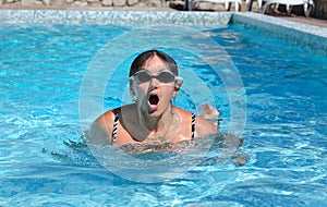 Woman swimming in a pool coming up to gasp for air photo