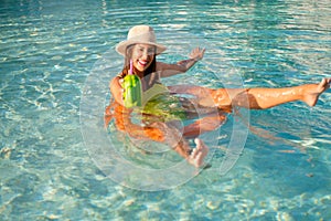 Woman swimming in the pool and enjoying the sun