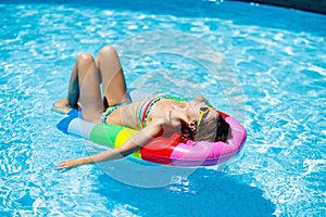 Woman in swimming pool on float. Female swimming