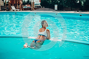 woman swimming pool. happy woman with wet hair and stylish sunglasses sunbathing in pool
