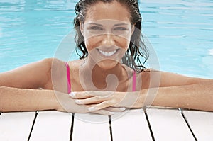 Woman in Swimming Pool resting on poolside portrait