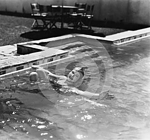 Woman swimming in a pool with a swimming cap