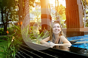 Woman swimming in pool in thailand looking up on sunny day