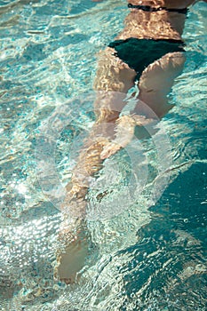 Woman swimming in the sea. Female legs under clear sea water.