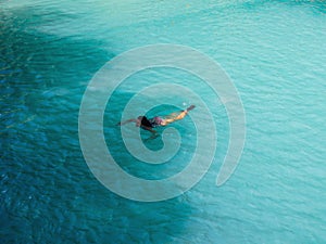 Woman swimming  turquoise water of cambugahay waterfalls in Siquijor Island