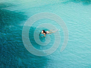 Woman swimming  turquoise water of cambugahay waterfalls in Siquijor Island
