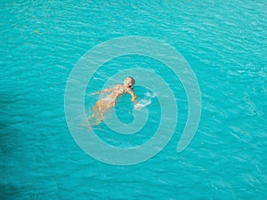 Woman swimming  turquoise water of cambugahay waterfalls in Siquijor Island