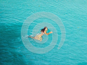 Woman swimming  turquoise water of cambugahay waterfalls in Siquijor Island