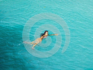 Woman swimming  turquoise water of cambugahay waterfalls in Siquijor Island