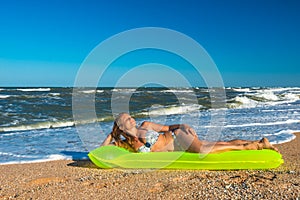 Woman in a swimsuit lies on an air mattress