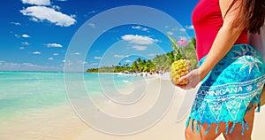 Woman in swimsuit and pina colada cocktail enjoying caribbean summer vacation on a tropical island beach in Dominican Republic