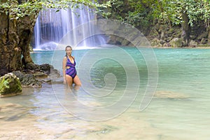 Woman with swimsuit stand relax at Erawan Waterfall