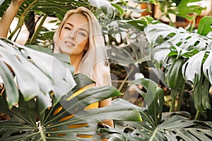 Woman in swimsuit on tropical plants background