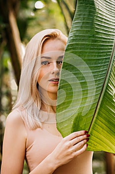 Woman in swimsuit on tropical plants background