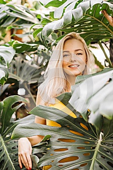 Woman in swimsuit on tropical plants background