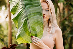 Woman in swimsuit on tropical plants background