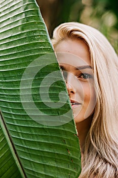 Woman in swimsuit on tropical plants background