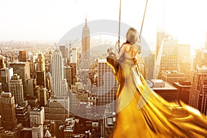 Woman on a swing above New York City