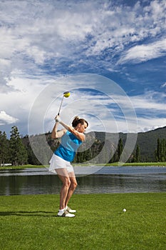 Woman Swinging Golf Club