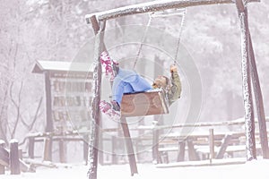 Woman swinging outdoors on snowy winter day