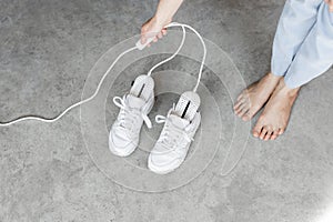 Woman switches electric shoe dryer drying her white sneakers