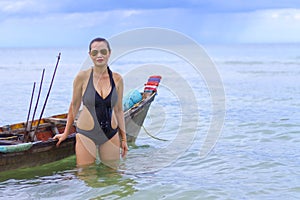 Woman symbol black bikini and small boat on beach