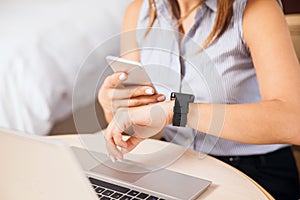 Woman syncing smart watch to smartphone