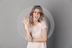 Woman in t-shirt showing ok sign while looking at camera