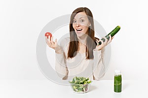 Woman at table with green detox smoothies, fresh salad in glass bowl, tomato, cucumber isolated on white background