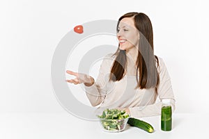 Woman at table with green detox smoothies, fresh salad in glass bowl, tomato, cucumber isolated on white background