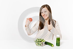 Woman at table with green detox smoothies, fresh salad in glass bowl, tomato, cucumber isolated on white background