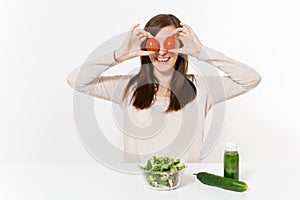 Woman at table with green detox smoothies, fresh salad in glass bowl, tomato, cucumber isolated on white background