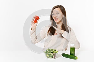 Woman at table with green detox smoothies, fresh salad in glass bowl, tomato, cucumber isolated on white background