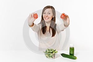 Woman at table with green detox smoothies, fresh salad in glass bowl, tomato, cucumber isolated on white background