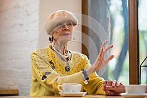 Woman at table near window.