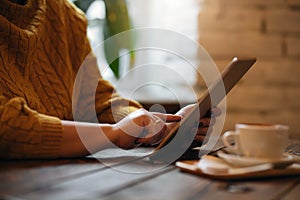 Woman with tablet behind table