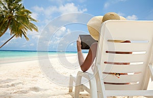 Woman with tablet computer on the beach