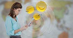 Woman with tablet and emojis with flare against blurry map