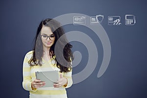 Woman with tablet in front of background with drawn business chart and icons.