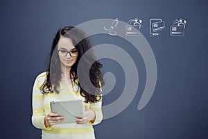 Woman with tablet in front of background with drawn business chart and icons.