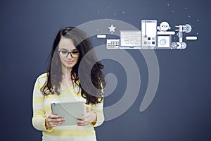 Woman with tablet in front of background with drawn business chart and icons.