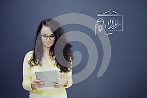 Woman with tablet in front of background with drawn business chart and icons.