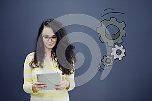 Woman with tablet in front of background with drawn business chart and icons.