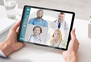 Woman With Tablet Having Consultation With Doctors Via Video Call