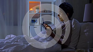 woman with tablet pc in bed at home at night