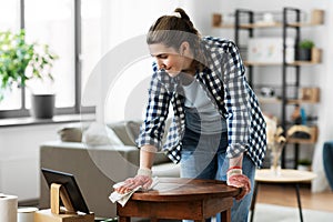 woman with tablet pc cleaning table with tissue