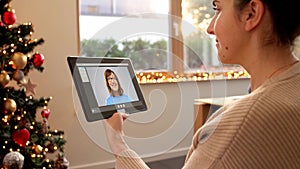 woman with tablet pc has video call on christmas