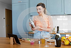 woman with tablet pc making cocktails at kitchen