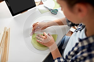 woman with tablet pc making paper craft at home